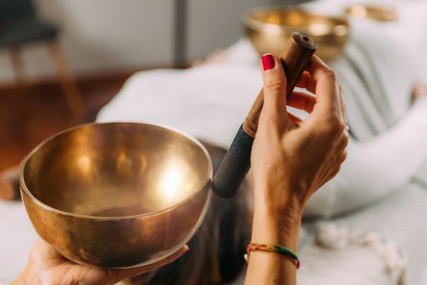 A képen egy nő a bal kezében lévő hangtálat a jobb kezével szólaltatja meg. Csak a kezeit látjuk, az ő szemszögéből, a háttérben egy fehér ruhás nő fekszik, akinek a hasán szintén egy hangtál van.